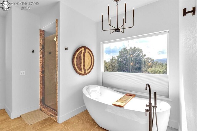 bathroom featuring tile patterned flooring, shower with separate bathtub, and a notable chandelier