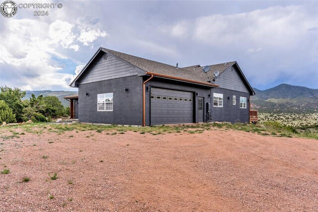 view of property exterior with a garage and a mountain view