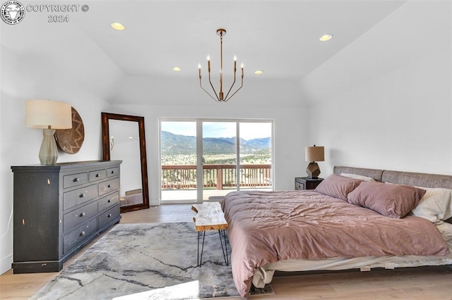 bedroom featuring lofted ceiling, a chandelier, access to exterior, light hardwood / wood-style floors, and a mountain view