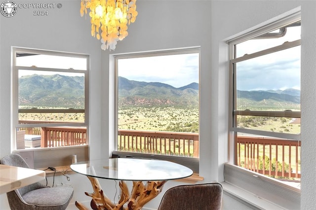 sunroom / solarium featuring a mountain view and a chandelier