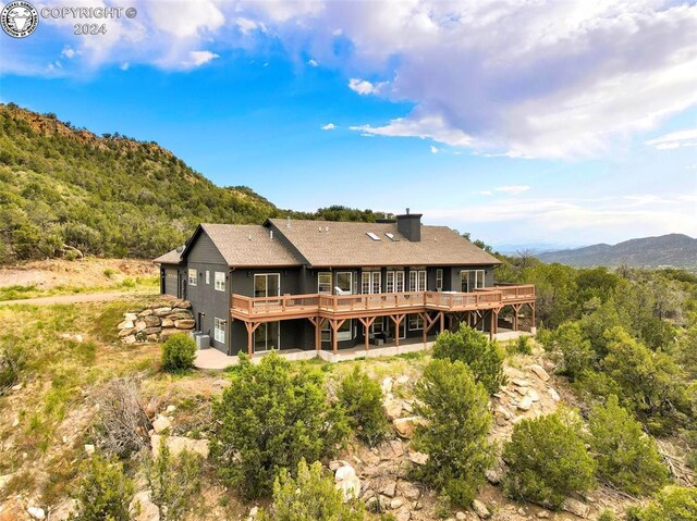 rear view of house with a deck with mountain view