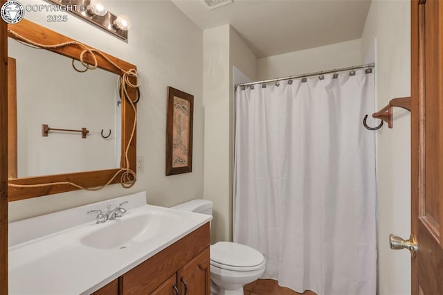 bathroom featuring visible vents, curtained shower, vanity, and toilet