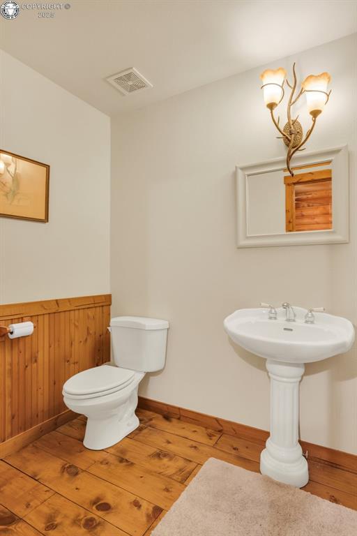 bathroom featuring baseboards, visible vents, toilet, and hardwood / wood-style floors