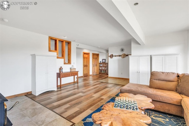 living room with wood finished floors, beam ceiling, and baseboards