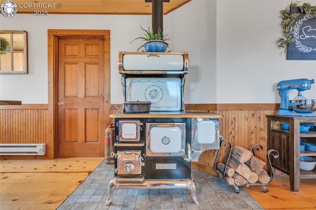 interior space featuring a wainscoted wall, a baseboard radiator, wood finished floors, and wood walls