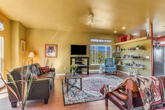 living room featuring hardwood / wood-style flooring and ceiling fan