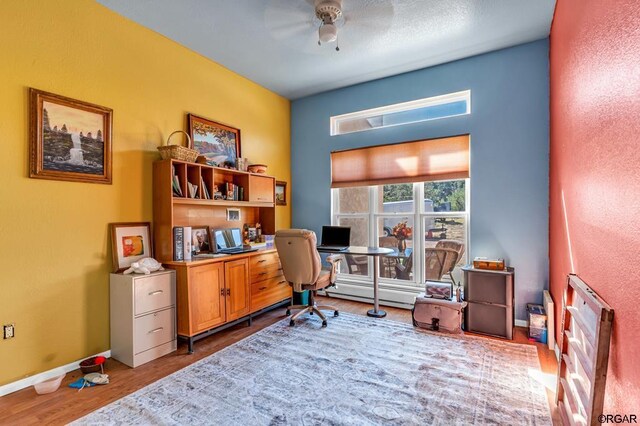 office with wood-type flooring and baseboard heating