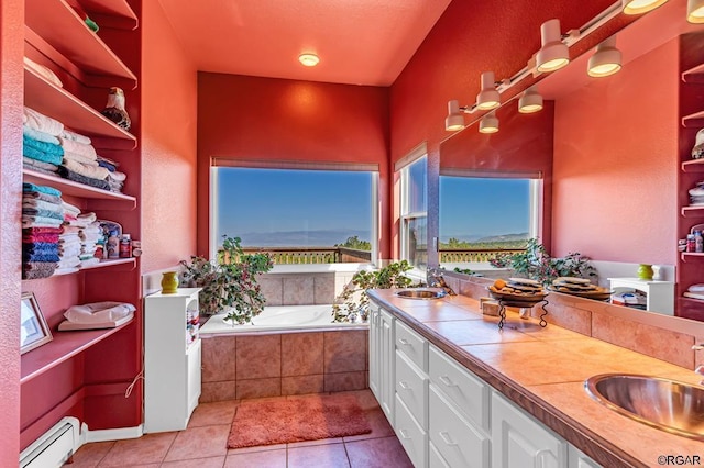 bathroom featuring tiled tub, vanity, tile patterned flooring, and baseboard heating