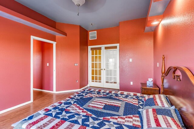 bedroom with hardwood / wood-style flooring, ceiling fan, and french doors