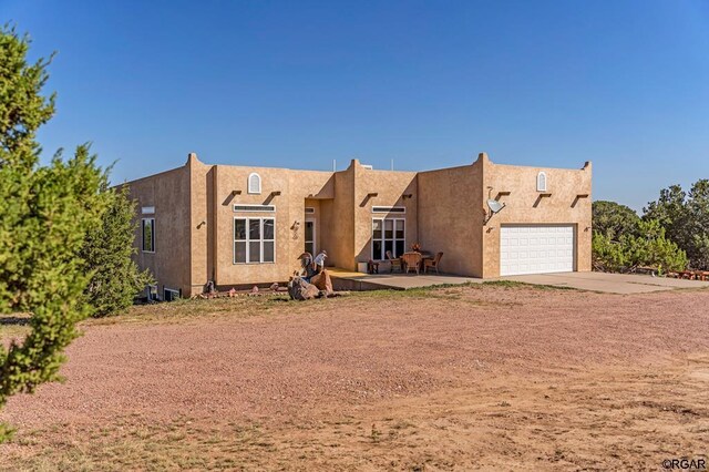 pueblo-style home with a garage