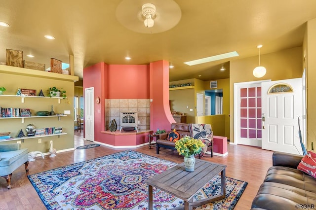 living room with a skylight, hardwood / wood-style floors, and heating unit