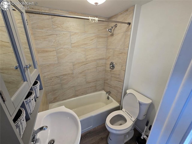 full bathroom with sink, tiled shower / bath combo, wood-type flooring, and toilet