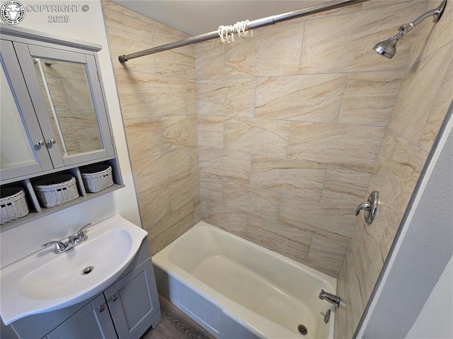 bathroom featuring vanity and tiled shower / bath