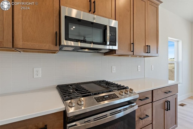 kitchen with stainless steel appliances and light hardwood / wood-style floors