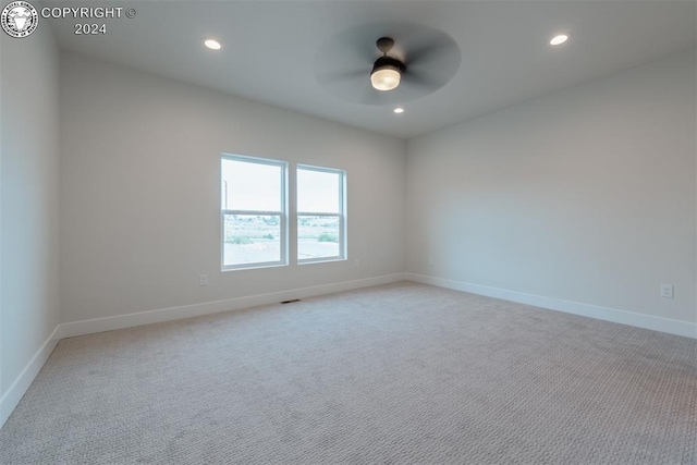 spare room featuring light colored carpet and ceiling fan