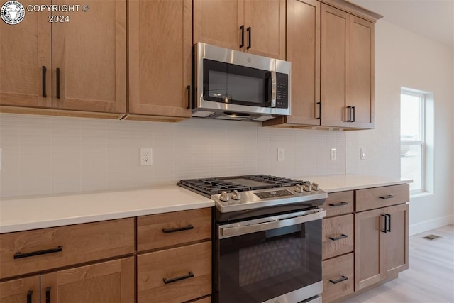 kitchen featuring appliances with stainless steel finishes and light hardwood / wood-style floors