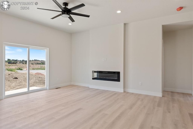 unfurnished living room featuring heating unit, light hardwood / wood-style flooring, and ceiling fan