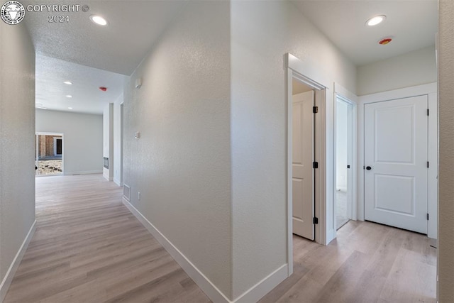 corridor with light hardwood / wood-style flooring