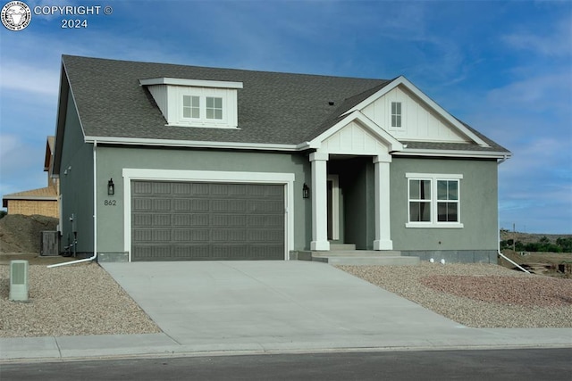 view of front of property featuring concrete driveway, an attached garage, and a shingled roof