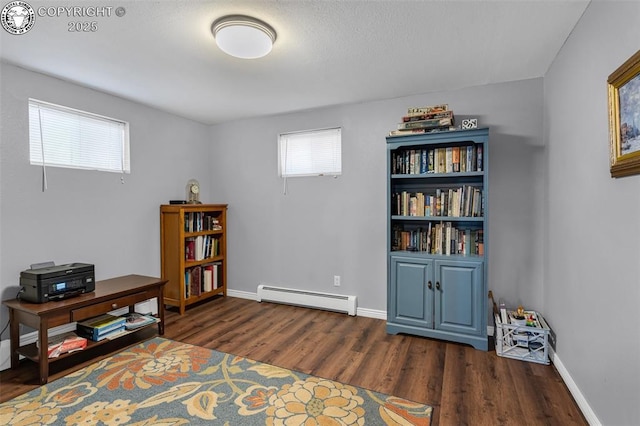 interior space with a baseboard heating unit and dark hardwood / wood-style flooring