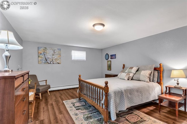 bedroom featuring dark hardwood / wood-style flooring and a baseboard heating unit