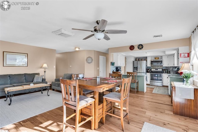 dining area with ceiling fan and light hardwood / wood-style floors