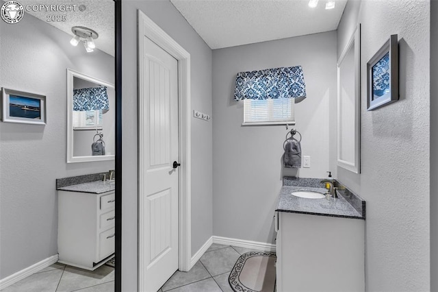 bathroom featuring tile patterned flooring, vanity, and a textured ceiling