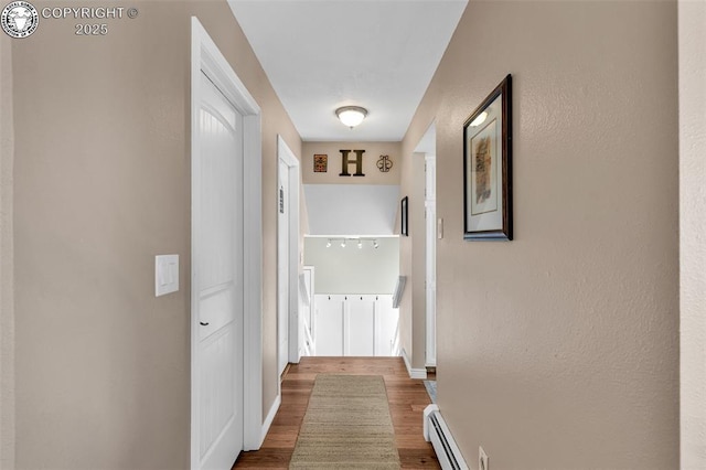 corridor with a baseboard radiator and wood-type flooring