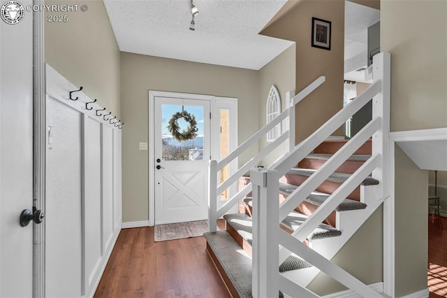 entryway featuring wood-type flooring and a textured ceiling