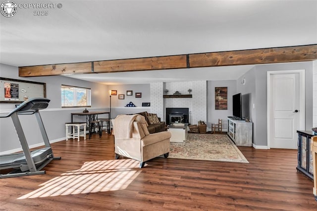 living room featuring beamed ceiling and dark hardwood / wood-style flooring