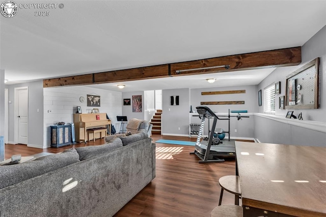 living room featuring beamed ceiling and dark hardwood / wood-style flooring