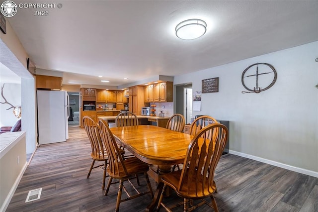 dining space with dark hardwood / wood-style flooring