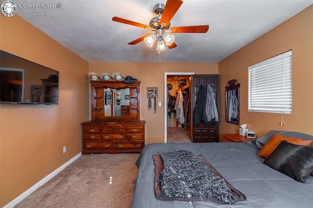 bedroom featuring ceiling fan, carpet flooring, a textured ceiling, a spacious closet, and a closet