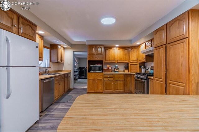 kitchen featuring dark wood-type flooring, appliances with stainless steel finishes, and sink