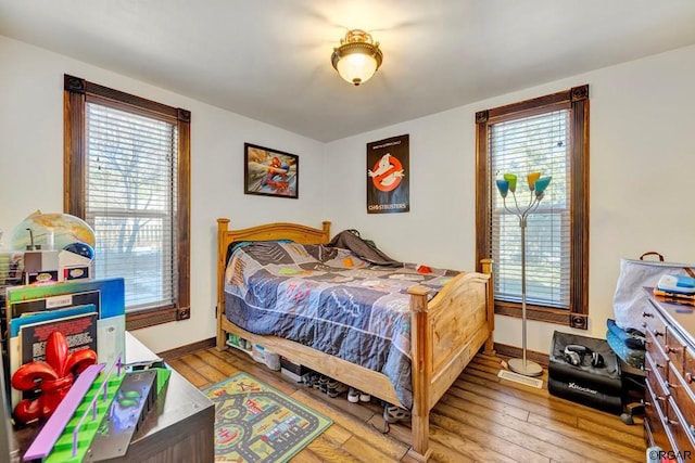 bedroom with multiple windows and light wood-type flooring