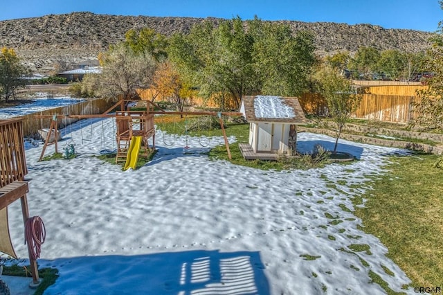 view of yard with a storage unit and a playground