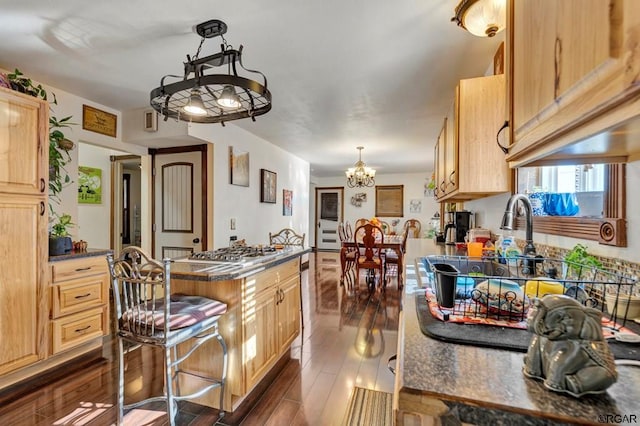 kitchen featuring dark hardwood / wood-style flooring, decorative light fixtures, a chandelier, and light brown cabinetry