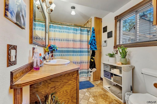 bathroom featuring vanity, toilet, and curtained shower