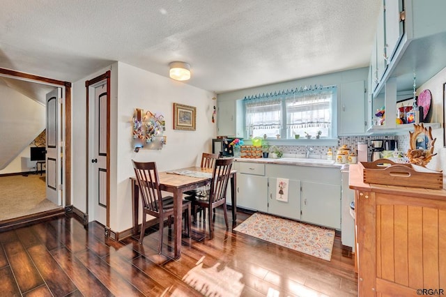 kitchen featuring sink, decorative backsplash, dark hardwood / wood-style floors, and a textured ceiling