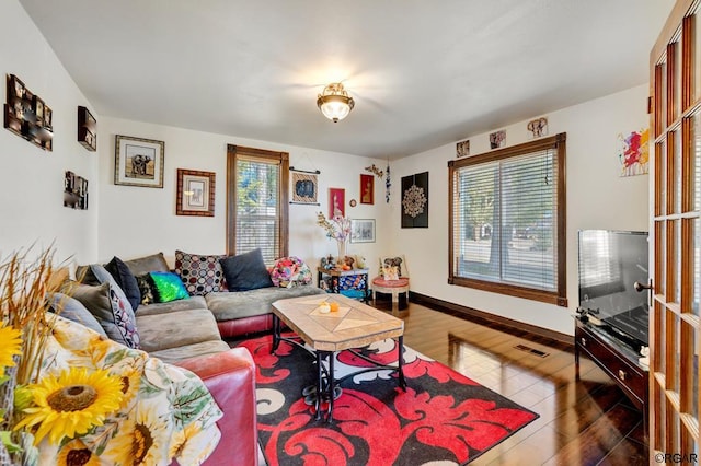 living room with dark wood-type flooring and a wealth of natural light