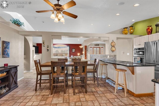 dining space with vaulted ceiling and ceiling fan