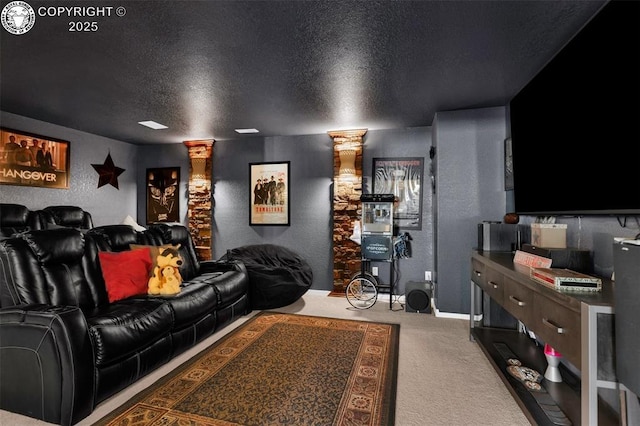 home theater featuring carpet floors, decorative columns, and a textured ceiling