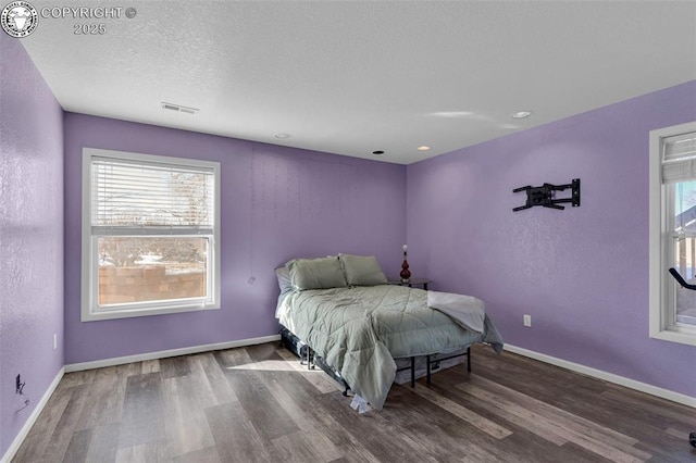 bedroom with dark hardwood / wood-style flooring and a textured ceiling