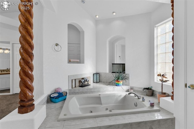 bathroom featuring vanity and tiled bath