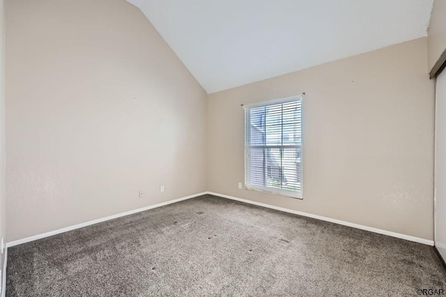 empty room with carpet floors and vaulted ceiling