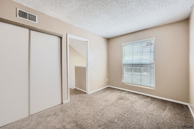 unfurnished bedroom featuring carpet flooring, a closet, and a textured ceiling