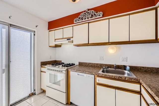 kitchen with light tile patterned flooring, sink, white cabinets, and white appliances