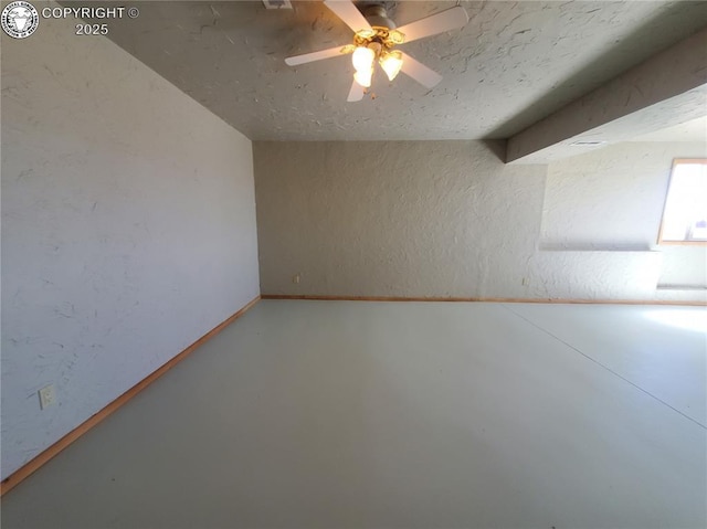 empty room featuring concrete floors, a ceiling fan, and a textured wall