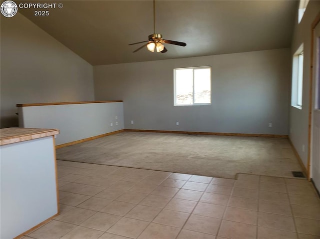 spare room with light tile patterned floors, ceiling fan, lofted ceiling, light carpet, and visible vents