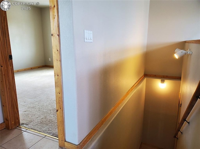 stairway with tile patterned flooring, baseboards, and carpet flooring